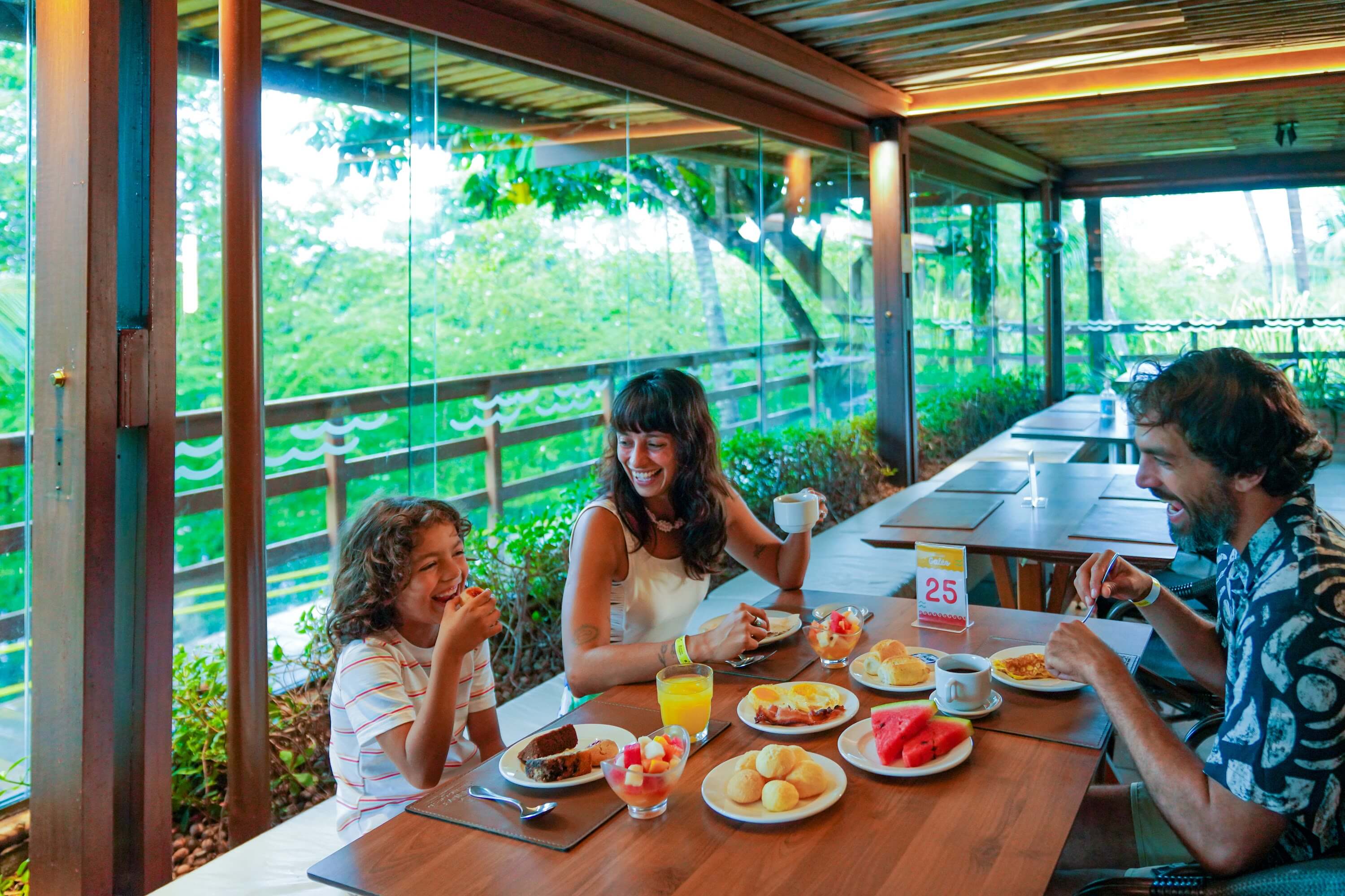 Família reunida em mesa aproveitando delícias do café da manHã no Restaurante Galés, do resort Salinas Maragogi.